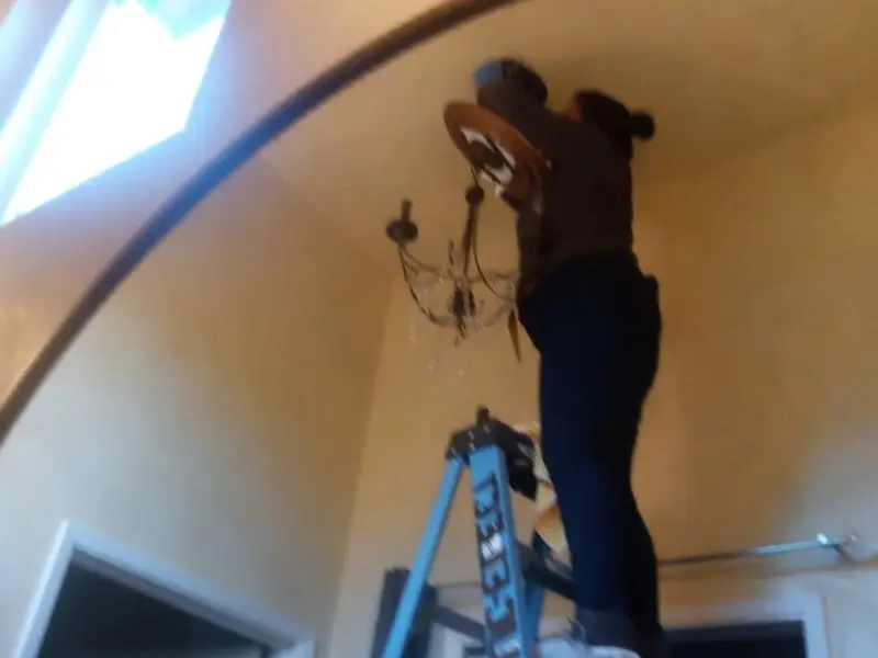 Electrician installing a chandelier in a Kirkland residence